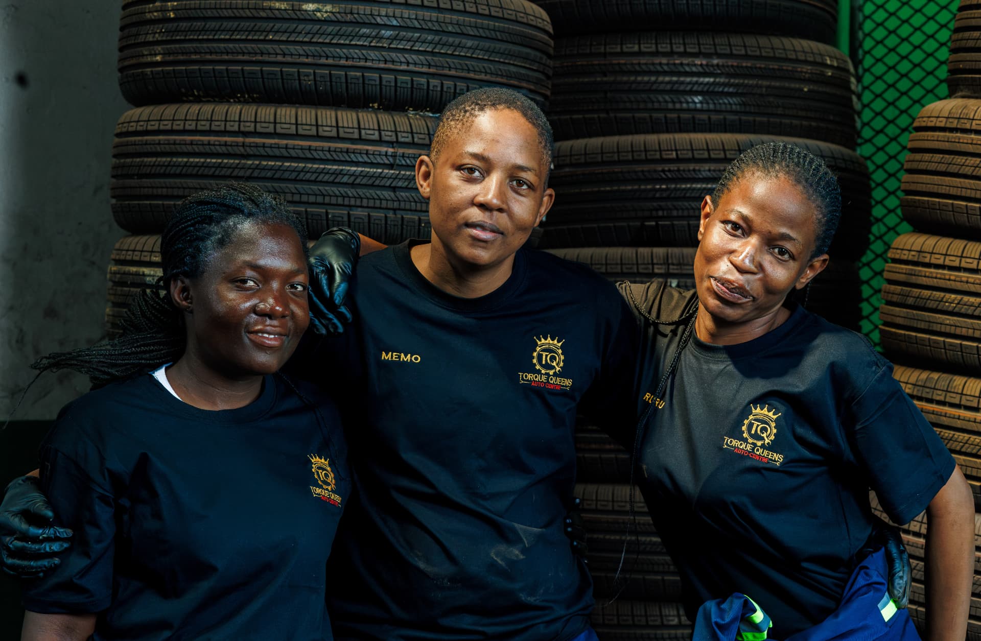 Memo and the Torque Queens technicians in front of stacked tyres